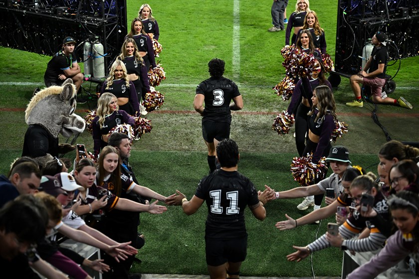 Kotoni Staggs runs out for the Broncos in their black jersey supporting the Black Dog Insitute.