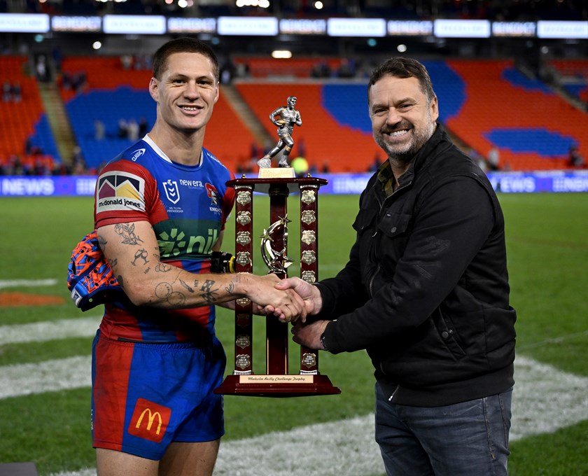 Kalyn Ponga receives the Malcolm Reilly Challenge Trophy from Malcolm's son Glen.